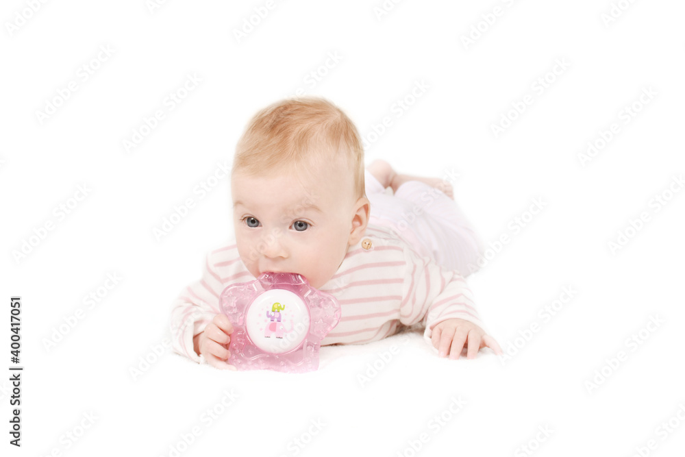 Cutest little 4 month old caucasian baby girl in striped T-shirt biting teether, isolated on white. Baby care and health concept. Copy space. Cutest little 4 month old caucasian baby girl in striped T-shirt biting teether, isolated on white. Baby care and health concept. Copy space.