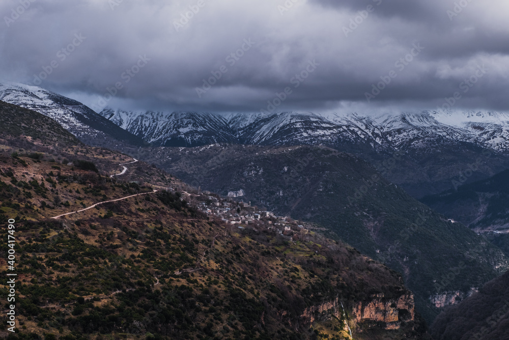 Fototapeta premium Kalarrytes village in Tzoumerka mountain range, view of summits in winter