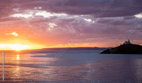 Greece  Kea Tzia island. Lighthouse on rocky cape  sky  sea background.