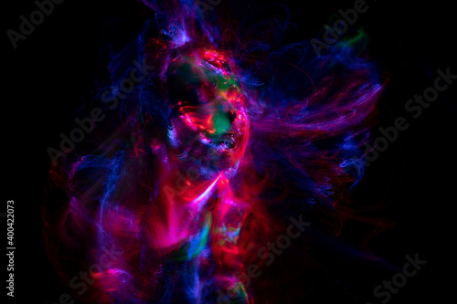 Portrait of a beautiful woman in colored beams of a projector. Streaks of light and shadow on the skin.