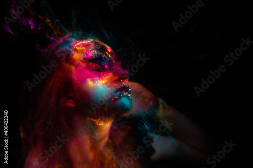 Portrait of a beautiful woman in colored beams of a projector. Streaks of light and shadow on the skin.
