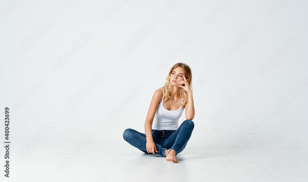 women legs crossed sitting on the floor indoors in jeans and t-shirt women legs crossed sitting on the floor indoors in jeans and t-shirt