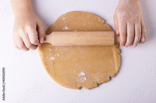 rolling out gingerbread dough with a wooden rolling pin, top view