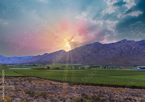 Hex River valley wine farms and mountains with sun rays behind the cloud in Western Cape South Africa photo