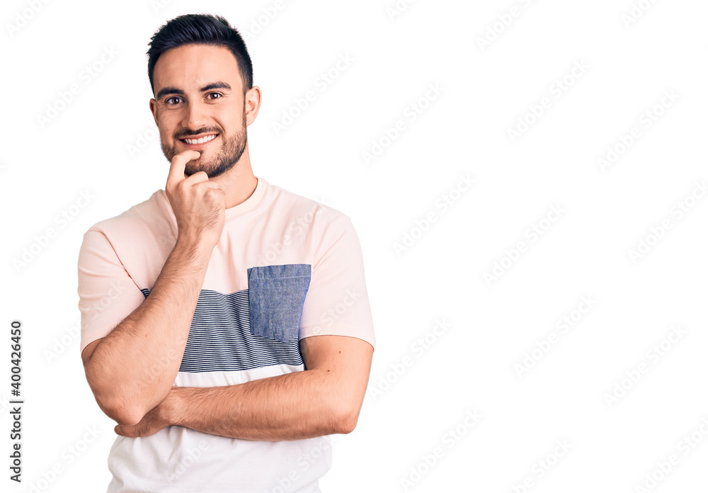 Young handsome man wearing casual clothes looking confident at the camera with smile with crossed arms and hand raised on chin. thinking positive. Young handsome man wearing casual clothes looking confident at the camera with smile with crossed arms and hand raised on chin. thinking positive.