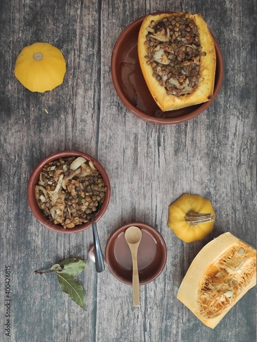 Baked butternut squash with lentils, olive oil  in wood background and yellow tablecloth photo