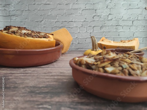 Baked butternut squash with lentils, olive oil  in wood background and yellow tablecloth photo