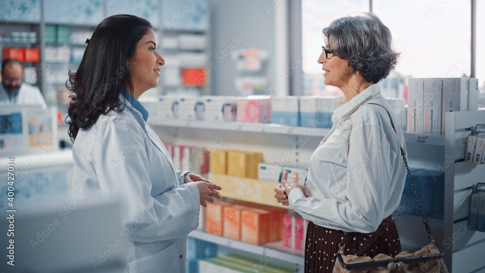 Pharmacy Drugstore: Senior Woman Chooses to Buy Medicine, Drugs, Vitamins. Professional, Helpful Pharmacist Advicing Customer Best Option. Modern Pharma Store Health Care Products