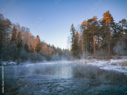 Winter landscape the river in the forest at sunset. Winter sunset rural river landscape. © Anatoliy