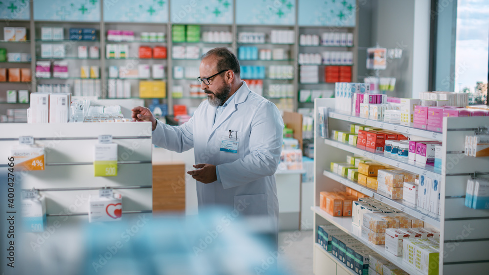 Pharmacy Drugstore: Beautiful Latin Pharmacist Malse Checks Inventory of Medicine, Drugs, Vitamins, Health Care Products on a Shelf. Professional Pharmacist in Pharma Store