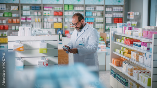 Pharmacy Drugstore: Beautiful Latin Pharmacist Malse Checks Inventory of Medicine, Drugs, Vitamins, Health Care Products on a Shelf. Professional Pharmacist in Pharma Store