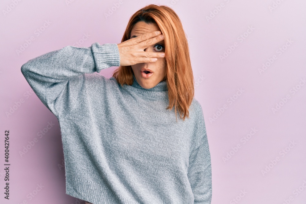 Hispanic young woman wearing casual turtleneck sweater peeking in shock covering face and eyes with hand, looking through fingers afraid Hispanic young woman wearing casual turtleneck sweater peeking in shock covering face and eyes with hand, looking through fingers afraid