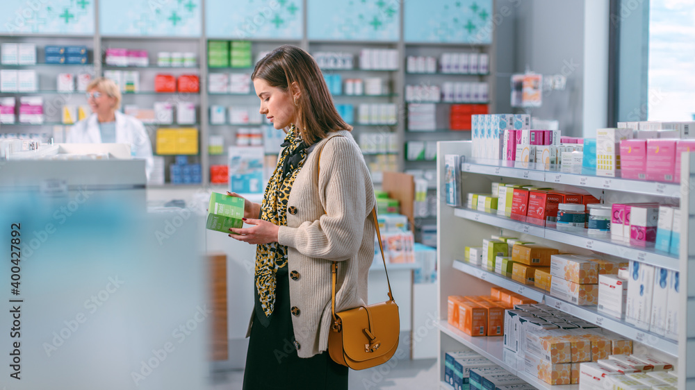 Pharmacy Drugstore: Portrait of Beautiful Young Woman Browsing to Buy Medicine, Drugs, Vitamins, Supplements. Chooses Right One. Pharma Store, Shelves full of Health Care, Beauty, Cosmetics Products