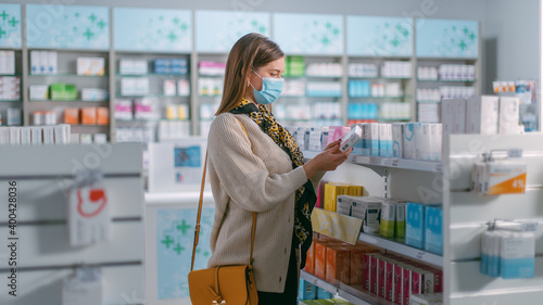 Pharmacy Drugstore: Portrait of Beautiful Young Woman Wears Protective Face Mask, Searches to Buy Best Medicine, Drugs, Vitamins. Shelves full of Health Care, Welness, Cosmetics, Beauty Products