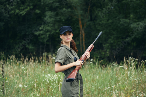 Woman on nature With arms in hand, a black cap is a lifestyle green overalls 