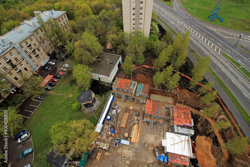 Land improvement. Accomplishment of territories near houses. yard is fenced. Construction of Playground on background of house. land without lawn. natural stone. Facing tiles. Paving slabs. Granite.