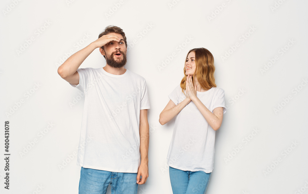 Happy man and woman in jeans and T-shirts on a light background cropped view