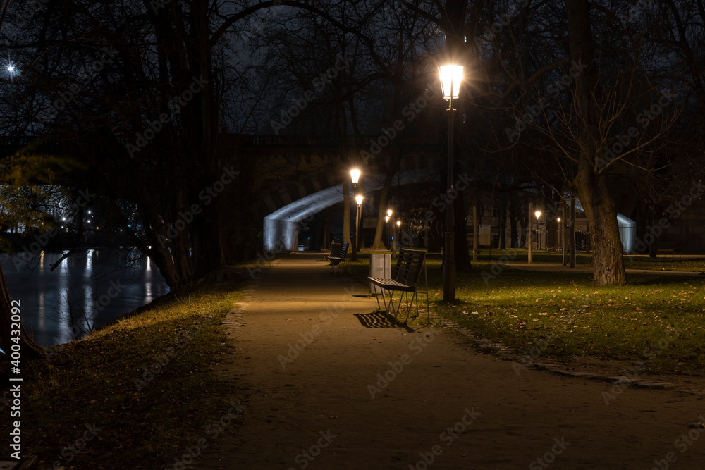 .light from street lights and a pedestrian chopper at night in a park in the Czech Republic