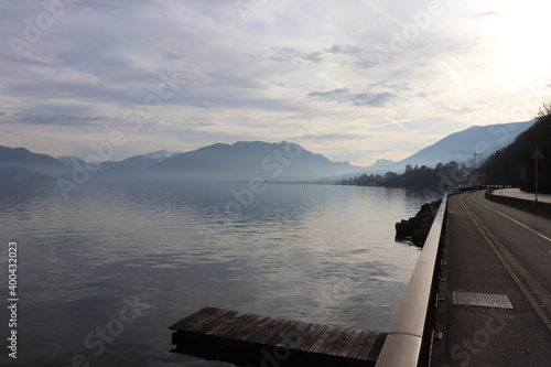 Le lac d'Annecy entouré de montagnes sous un ciel nuageux, ville de Annecy, département de Haute Savoie, France