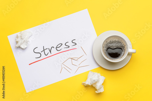 Paper sheet with word STRESS and cup of coffee on color background