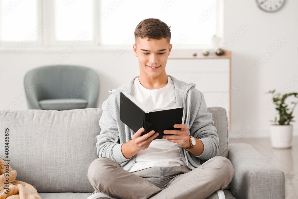Teenage boy reading book at home Teenage boy reading book at home
