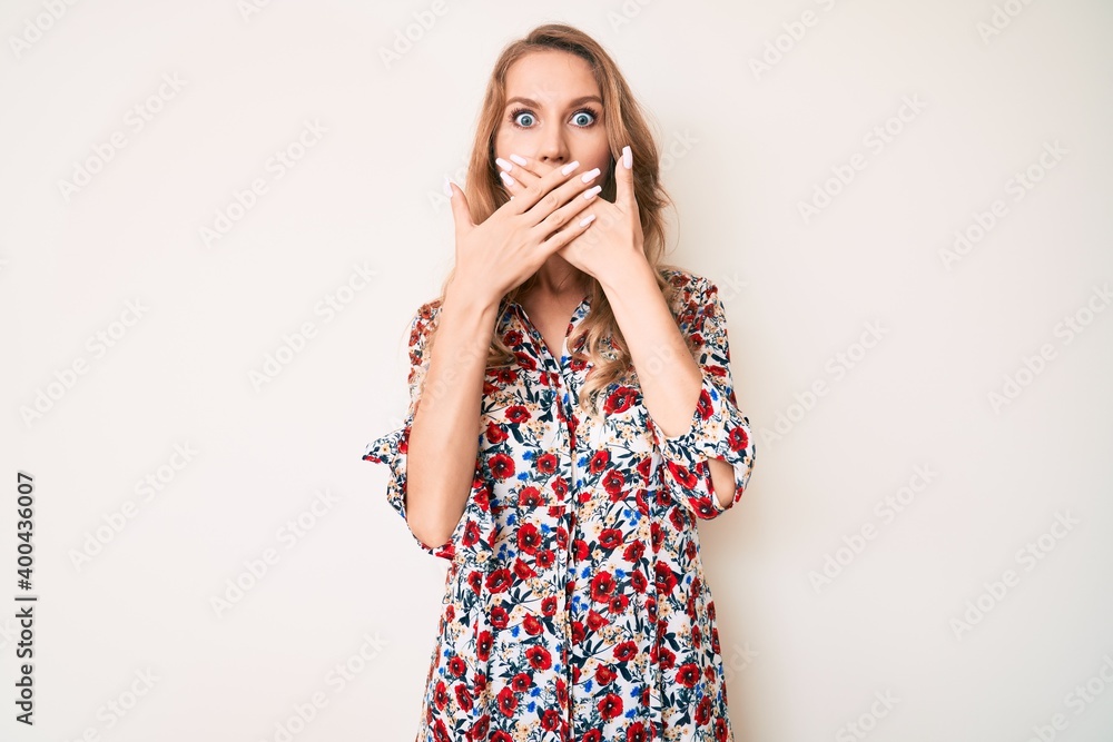 Young caucasian woman with blond hair wearing summer dress shocked covering mouth with hands for mistake. secret concept. Young caucasian woman with blond hair wearing summer dress shocked covering mouth with hands for mistake. secret concept.