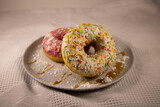 Sugar sweet donuts. Colored donut cakes on a plate that lie on a napkin.