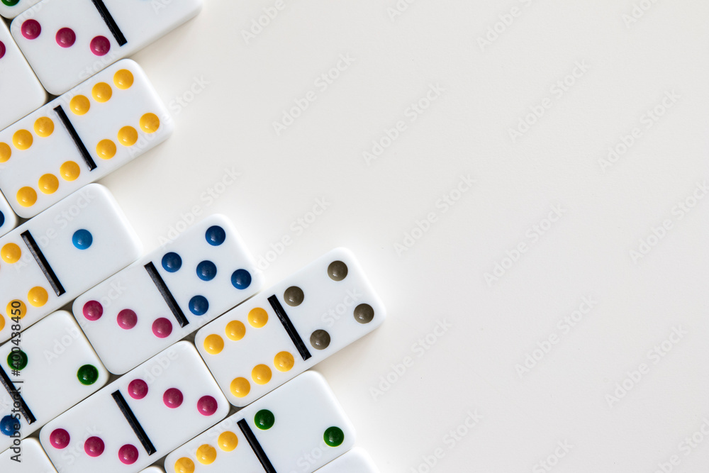 Colorful dominoes arranged on white background with negative space for copy Colorful dominoes arranged on white background with negative space for copy