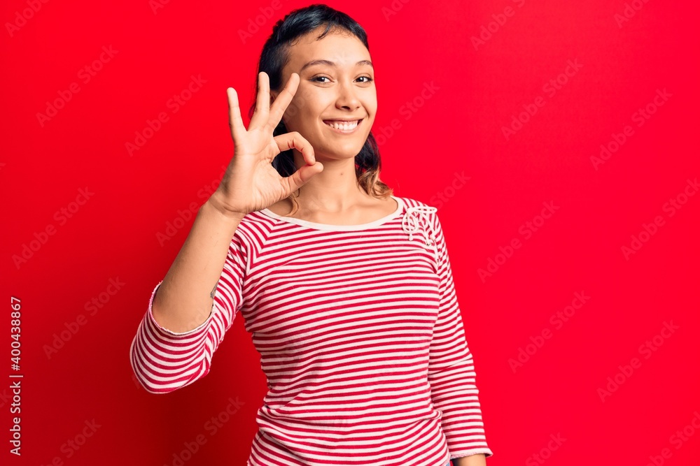 Young woman wearing casual clothes smiling positive doing ok sign with hand and fingers. successful expression. Young woman wearing casual clothes smiling positive doing ok sign with hand and fingers. successful expression.
