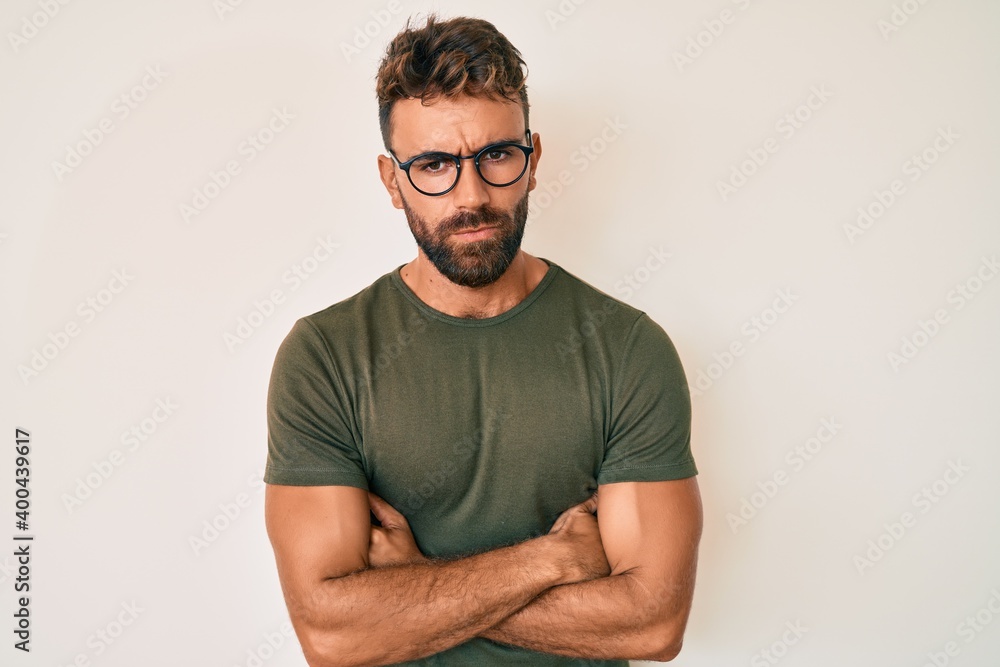 Young hispanic man wearing casual clothes and glasses skeptic and nervous, disapproving expression on face with crossed arms. negative person. Young hispanic man wearing casual clothes and glasses skeptic and nervous, disapproving expression on face with crossed arms. negative person.
