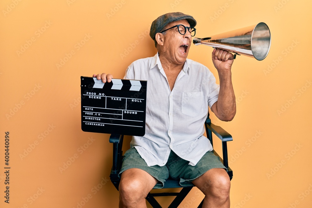 Φωτογραφία Handsome mature director man holding video film clapboard and louder angry and mad screaming frustrated and furious, shouting with anger