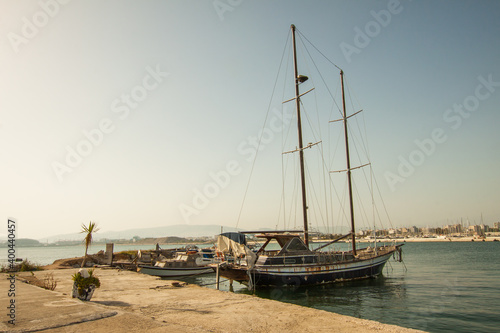 Abandoned sailing vessel moored on Athens pier in sunny day. Greece.