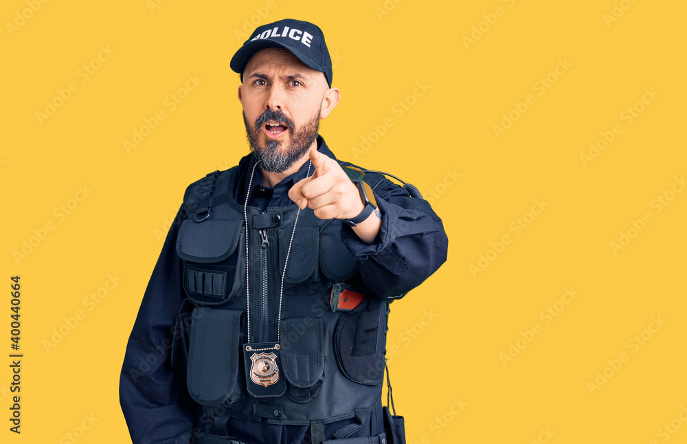 Young handsome man wearing police uniform pointing displeased and frustrated to the camera, angry and furious with you Young handsome man wearing police uniform pointing displeased and frustrated to the camera, angry and furious with you