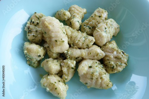 Gnocchi with pesto on a blue plate