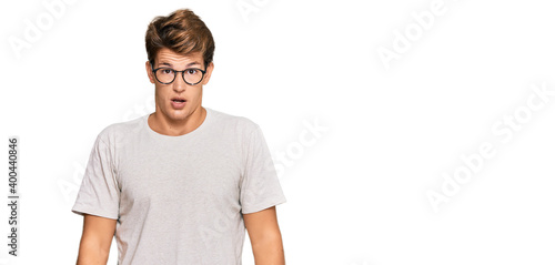 Handsome caucasian man wearing casual clothes and glasses afraid and shocked with surprise and amazed expression, fear and excited face.