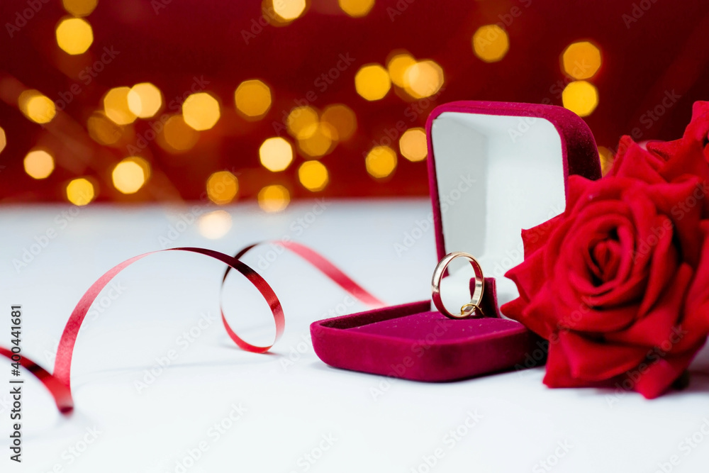 Banner. Gold ring, wedding ring in red box and , red rose on white-red  background with beautiful bokeh. The moment of a wedding, anniversary,  engagement, or Valentine's Day. Happy day. Stock Photo |