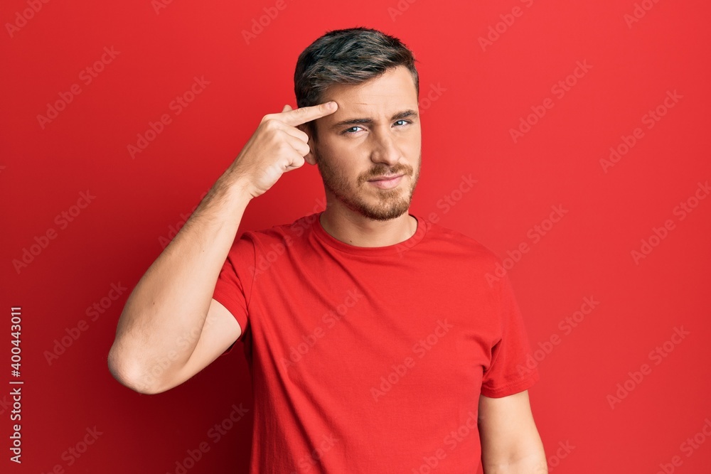 Handsome caucasian man wearing casual red tshirt pointing unhappy to pimple on forehead, ugly infection of blackhead. acne and skin problem Handsome caucasian man wearing casual red tshirt pointing unhappy to pimple on forehead, ugly infection of blackhead. acne and skin problem