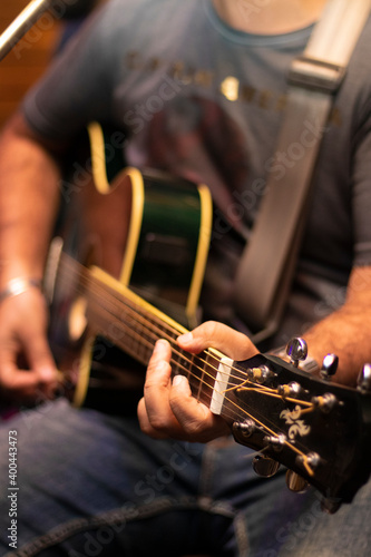 close up view of the hands of a guitarist playing guitar