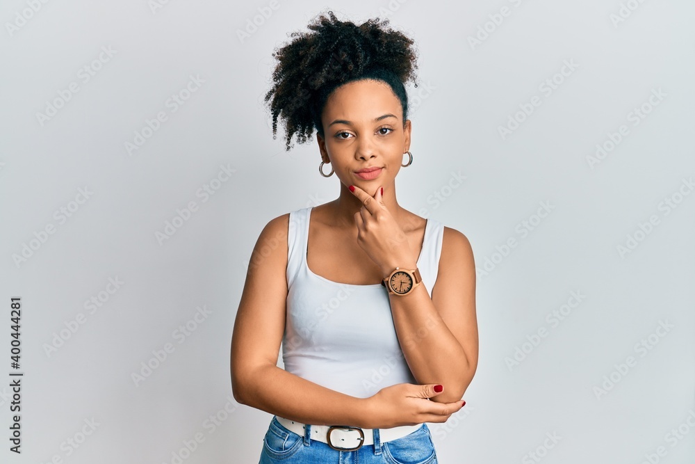 Young african american girl wearing casual style with sleeveless shirt thinking concentrated about doubt with finger on chin and looking up wondering Young african american girl wearing casual style with sleeveless shirt thinking concentrated about doubt with finger on chin and looking up wondering