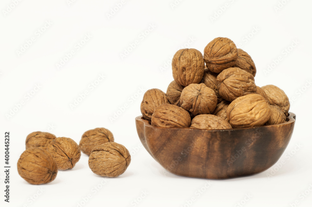 Natural walnut kernels in wooden bowl isolated on white background and copy space for text. Natural walnut kernels in wooden bowl isolated on white background and copy space for text.