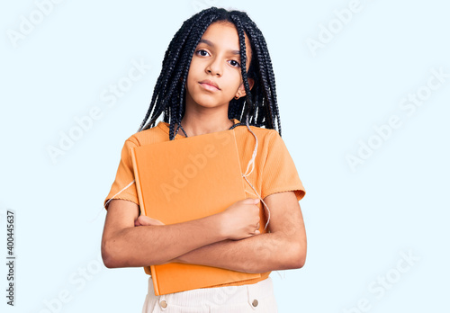 Obraz na plátně Cute african american girl holding notebook thinking attitude and sober expressi