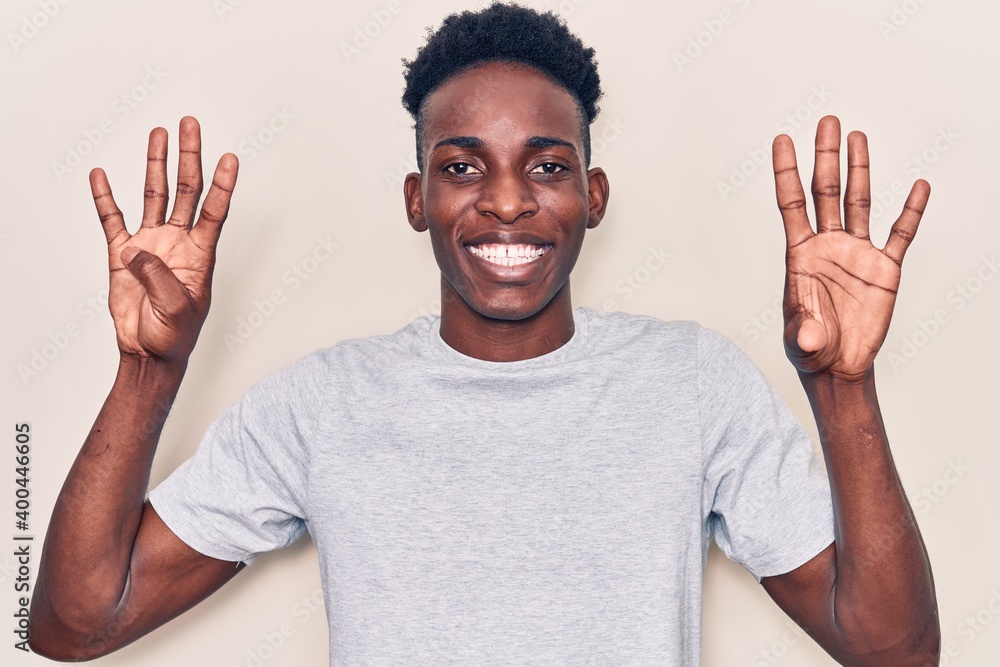 Naklejka premium Young african american man wearing casual clothes showing and pointing up with fingers number nine while smiling confident and happy.