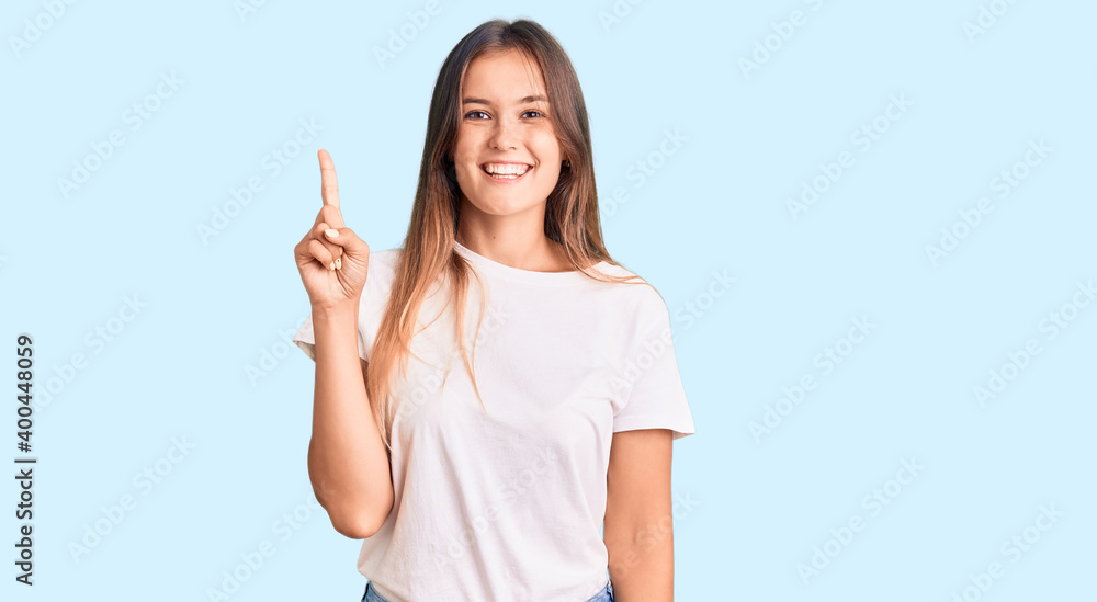 Beautiful caucasian woman wearing casual white tshirt showing and pointing up with finger number one while smiling confident and happy. Beautiful caucasian woman wearing casual white tshirt showing and pointing up with finger number one while smiling confident and happy.