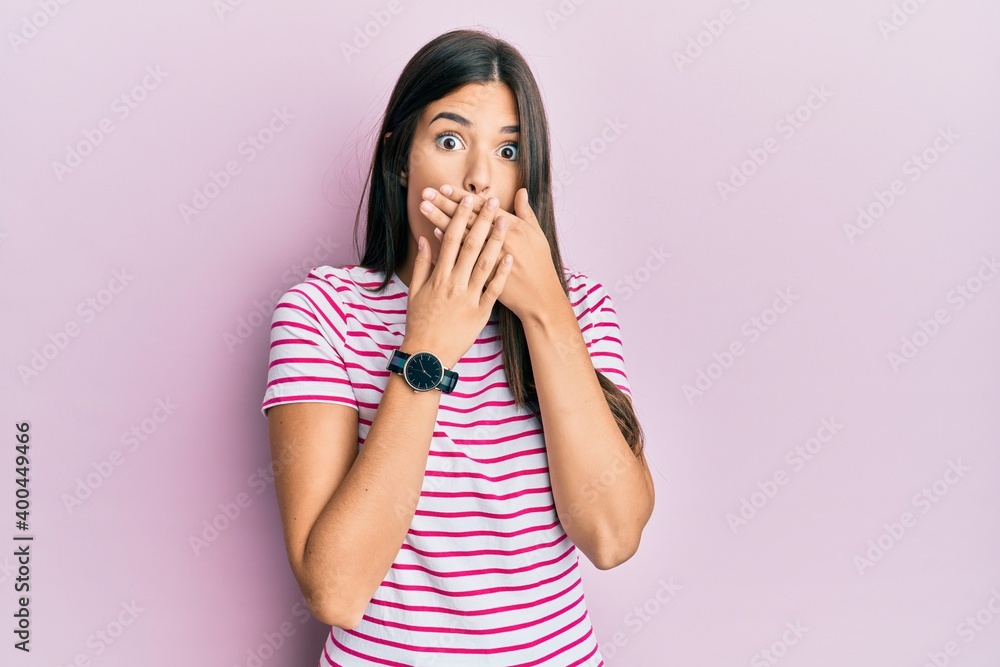 Young brunette woman wearing casual clothes over pink background shocked covering mouth with hands for mistake. secret concept. Young brunette woman wearing casual clothes over pink background shocked covering mouth with hands for mistake. secret concept.
