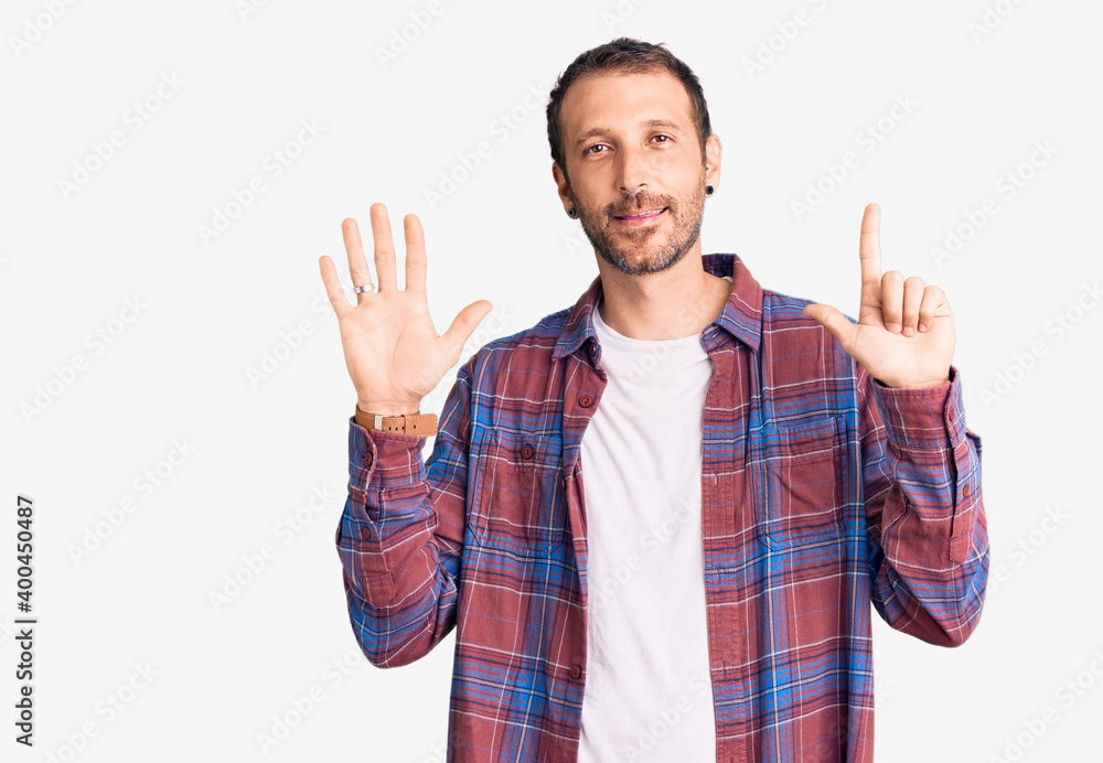 Young handsome man wearing casual clothes showing and pointing up with fingers number seven while smiling confident and happy. Young handsome man wearing casual clothes showing and pointing up with fingers number seven while smiling confident and happy.