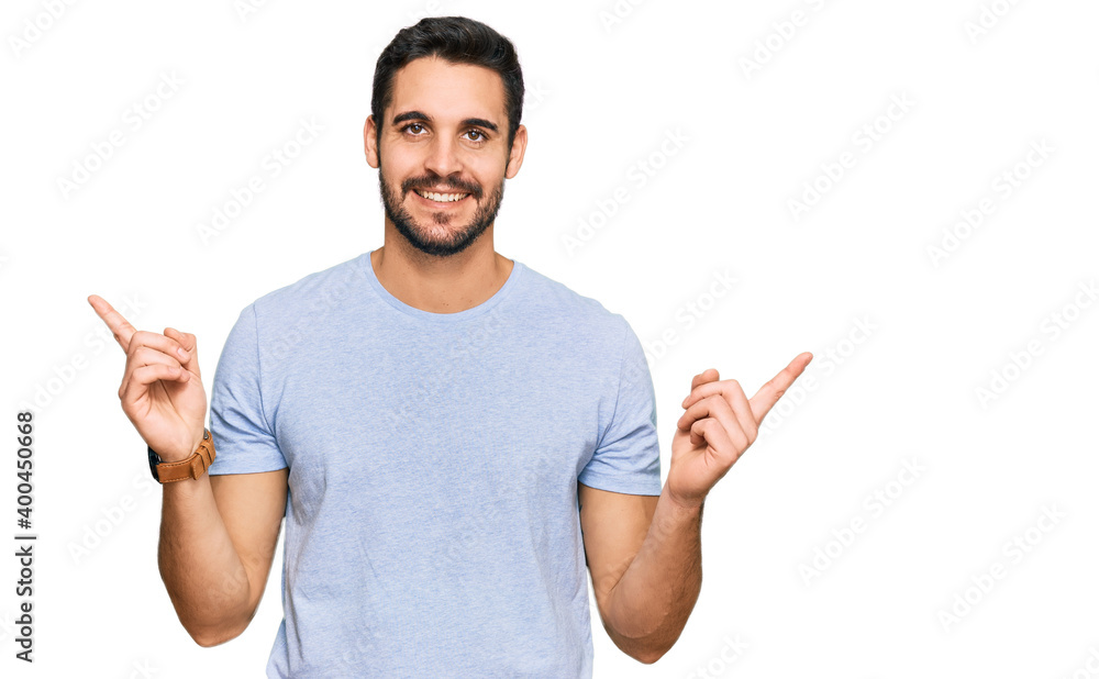 Young hispanic man wearing casual clothes smiling confident pointing with fingers to different directions. copy space for advertisement Young hispanic man wearing casual clothes smiling confident pointing with fingers to different directions. copy space for advertisement