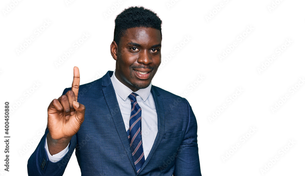 Handsome business black man wearing business suit and tie showing and pointing up with finger number one while smiling confident and happy. Handsome business black man wearing business suit and tie showing and pointing up with finger number one while smiling confident and happy.