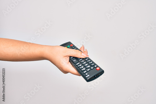 Canvas Print Hand of caucasian young woman changing television channel holding tv remote cont