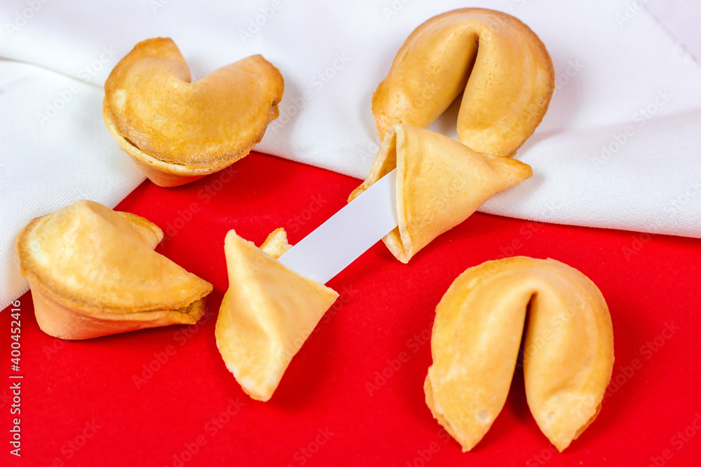 Fresh baked yellow Chinese fortune cookies with white blank note inside on red background. Fresh baked yellow Chinese fortune cookies with white blank note inside on red background.