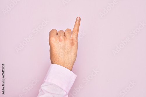 Hand of caucasian young man showing fingers over isolated pink background showing little finger as pinky promise commitment  number one